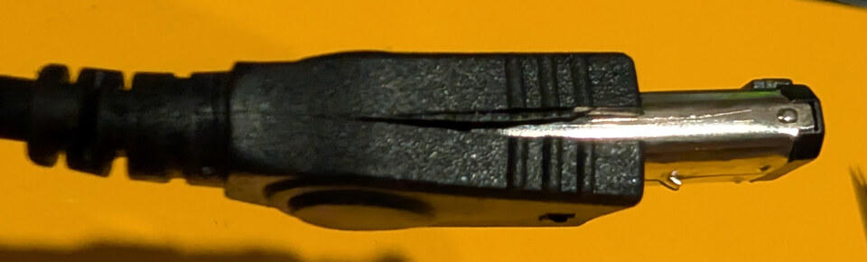 Cutting open the outer plastic sleeve to expose the connector's metal shell