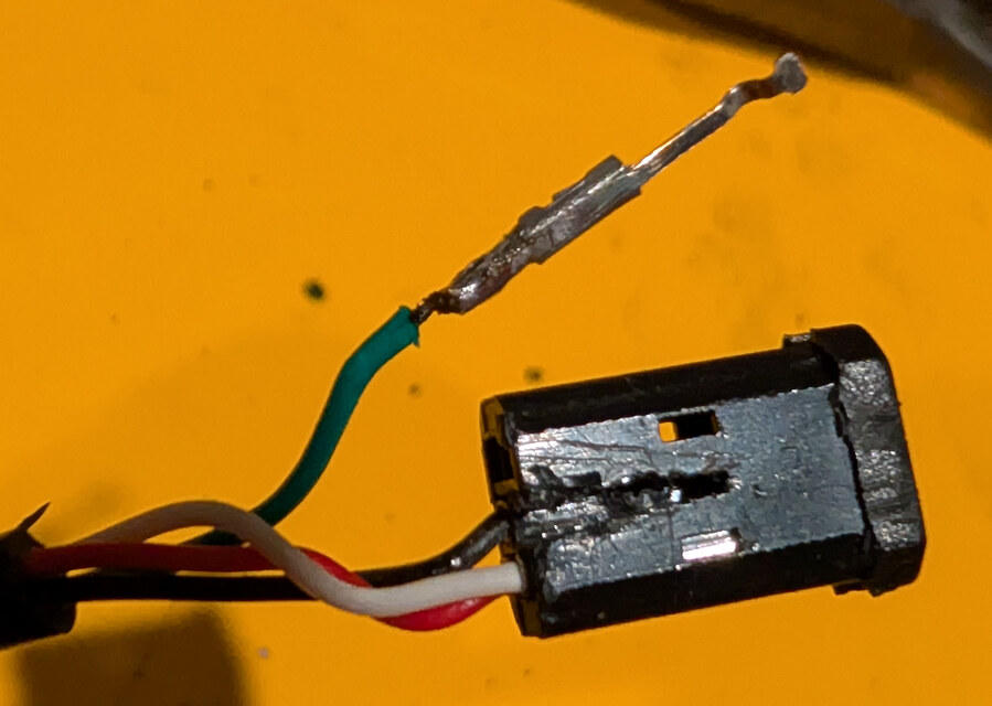 Removed connector contact with the green wire soldered back onto it